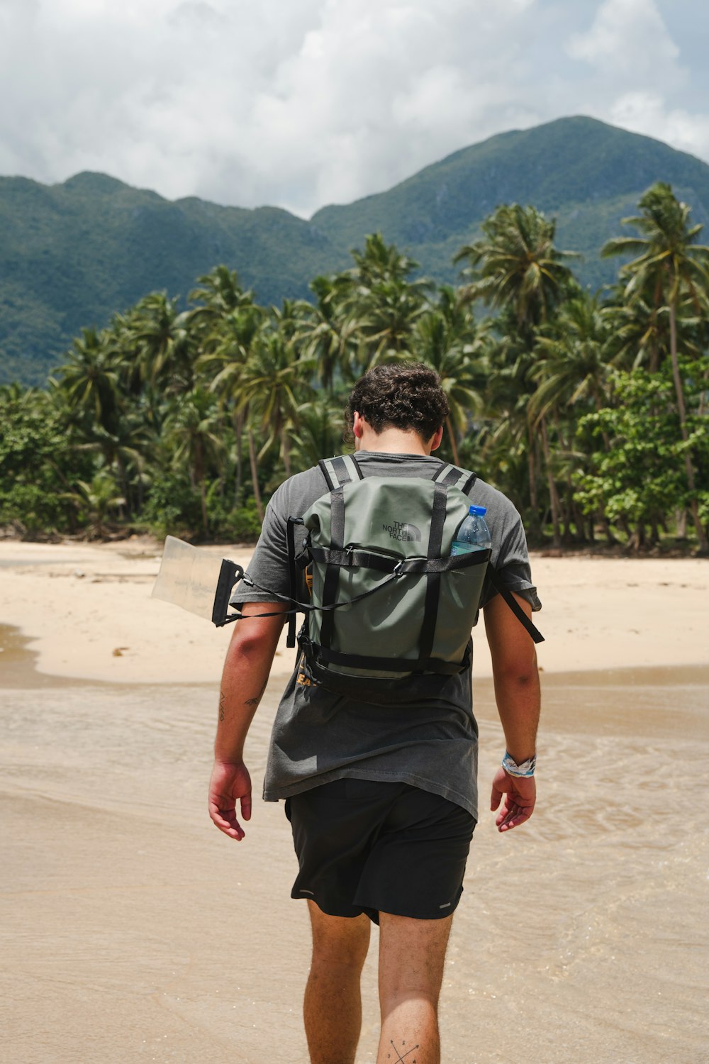 a man with a backpack walking on the beach