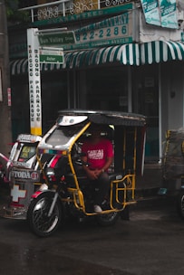 A tricycle wrapped with eye-catching promotional graphics parked outside a local shop.