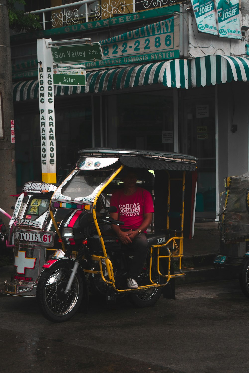 a man driving a three wheeled vehicle down a street