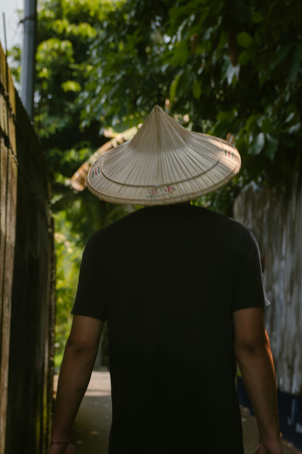 a man walking down a path with a hat on his head