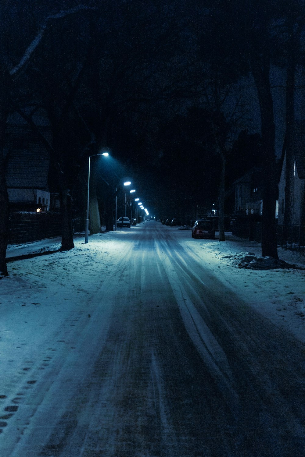 a snowy street at night with street lights on