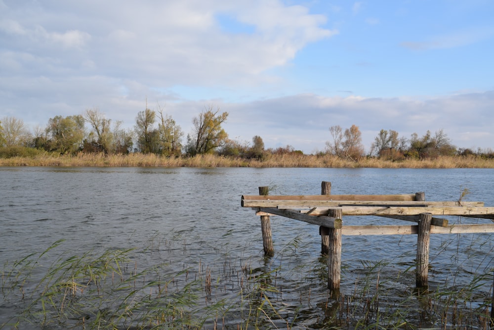 a wooden dock sitting in the middle of a lake