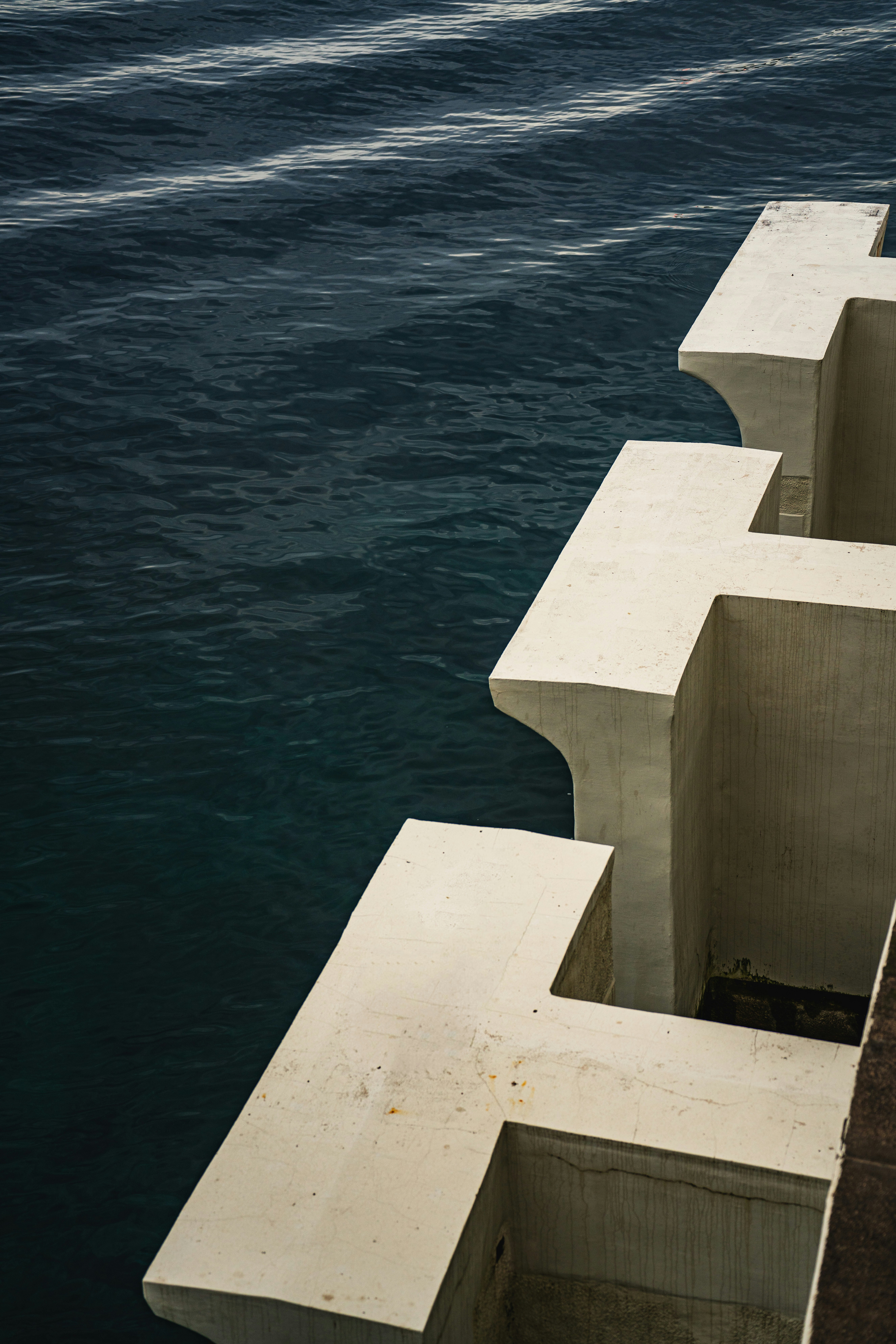 a bird is perched on a ledge over the water