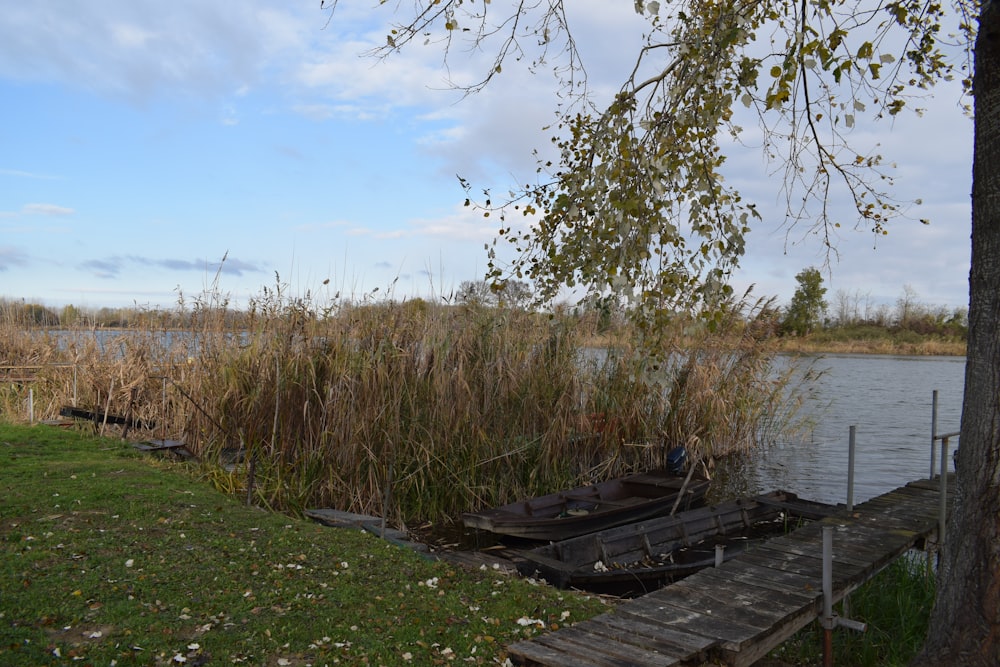 a boat sitting on top of a wooden dock next to a body of water