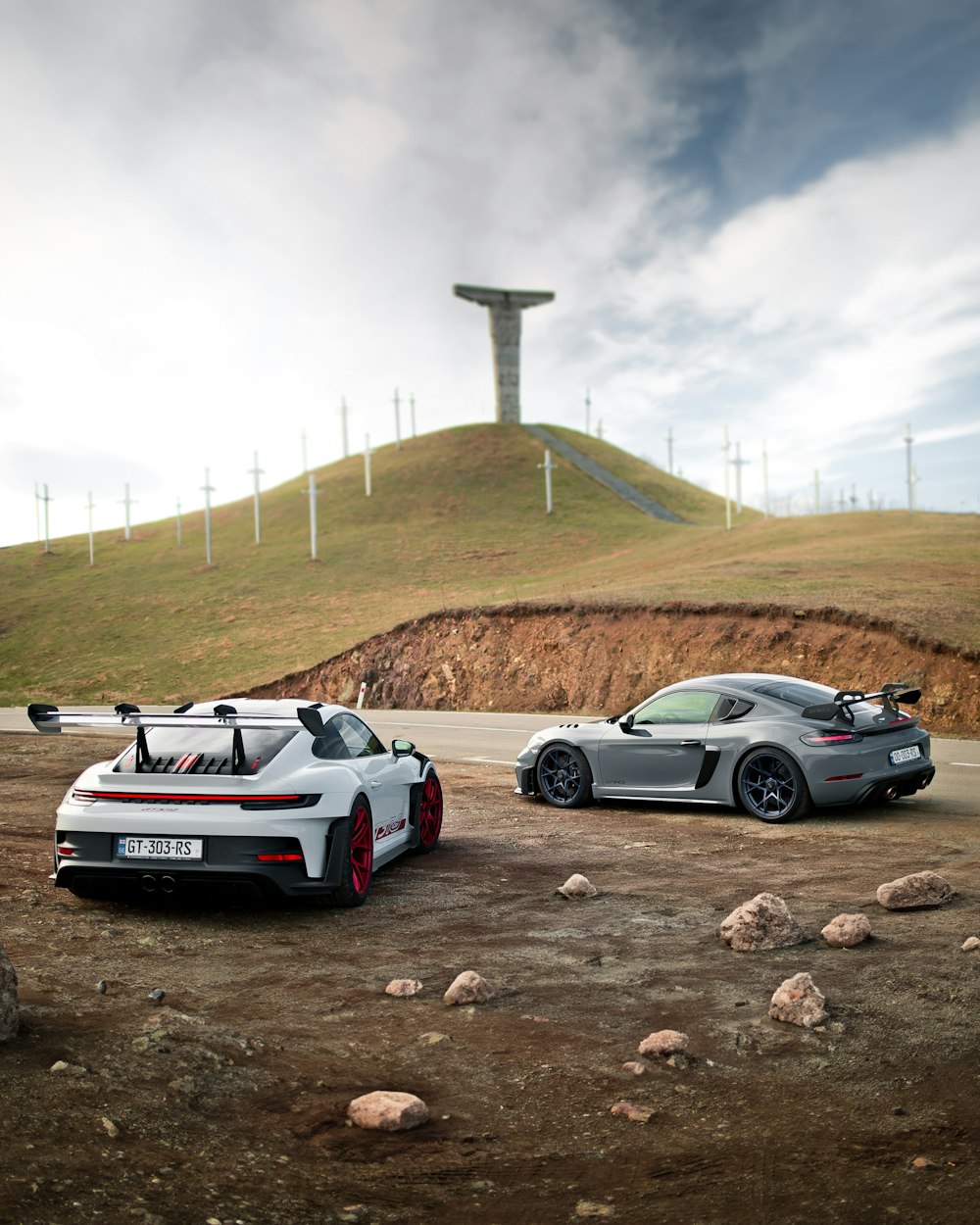 two sports cars parked on the side of a road