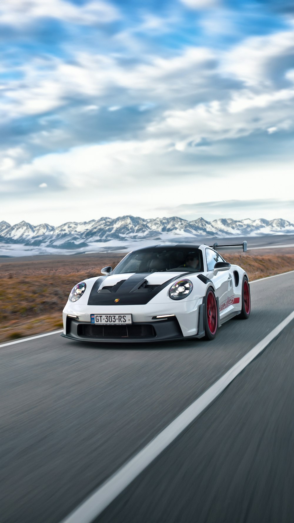 a white sports car driving down the road