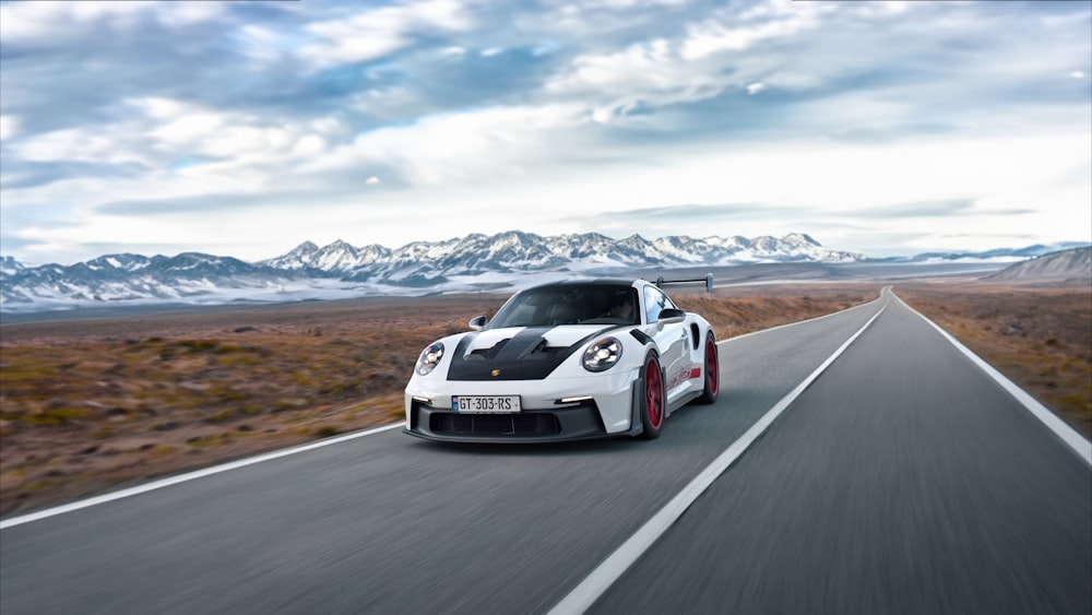 a white sports car driving down the road