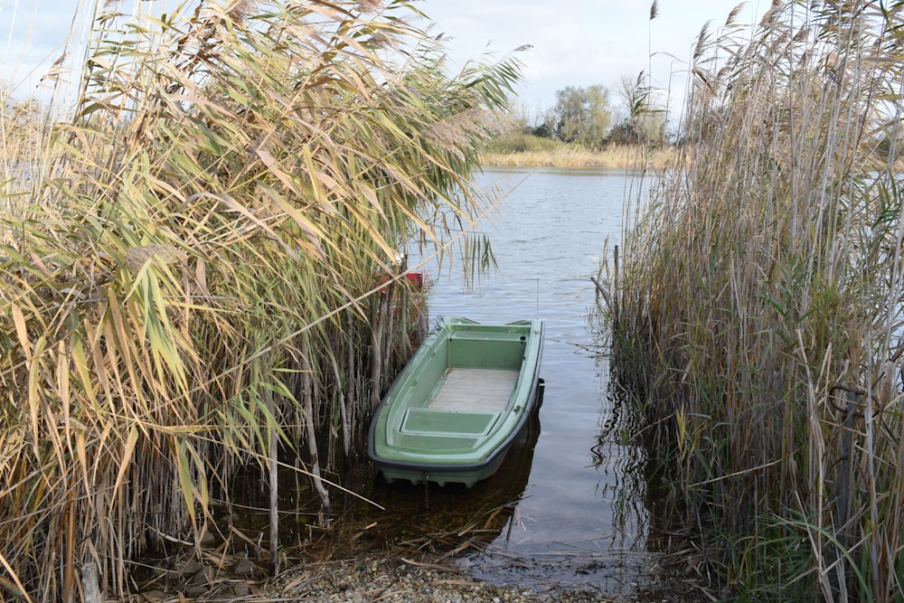a small green boat sitting in a body of water
