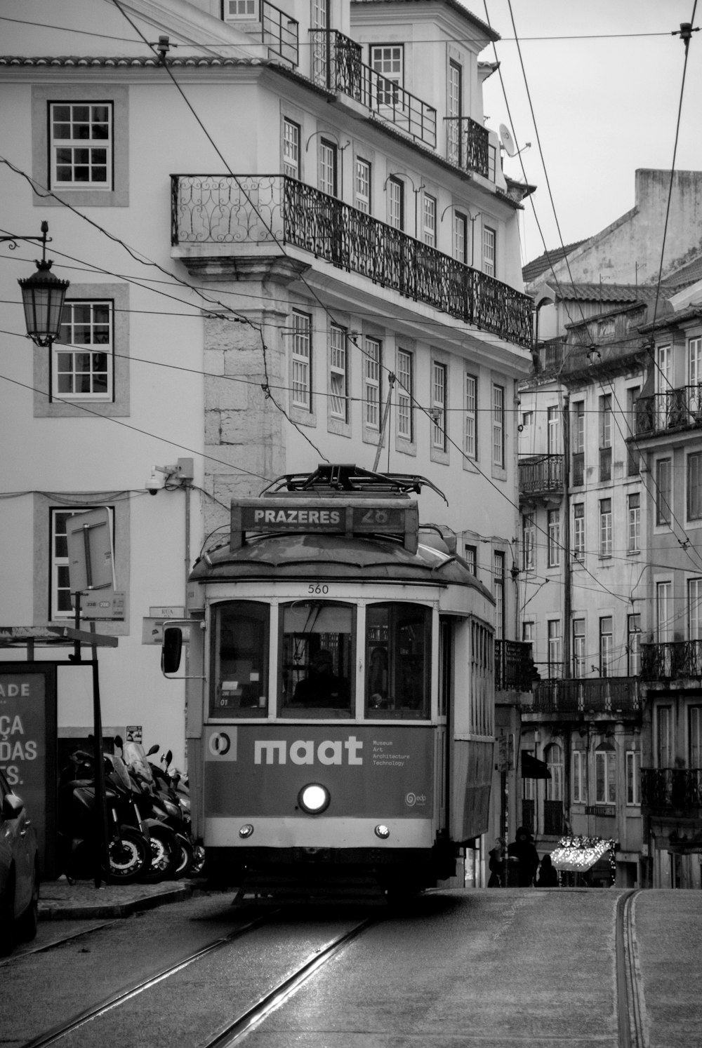 a black and white photo of a trolley on a city street