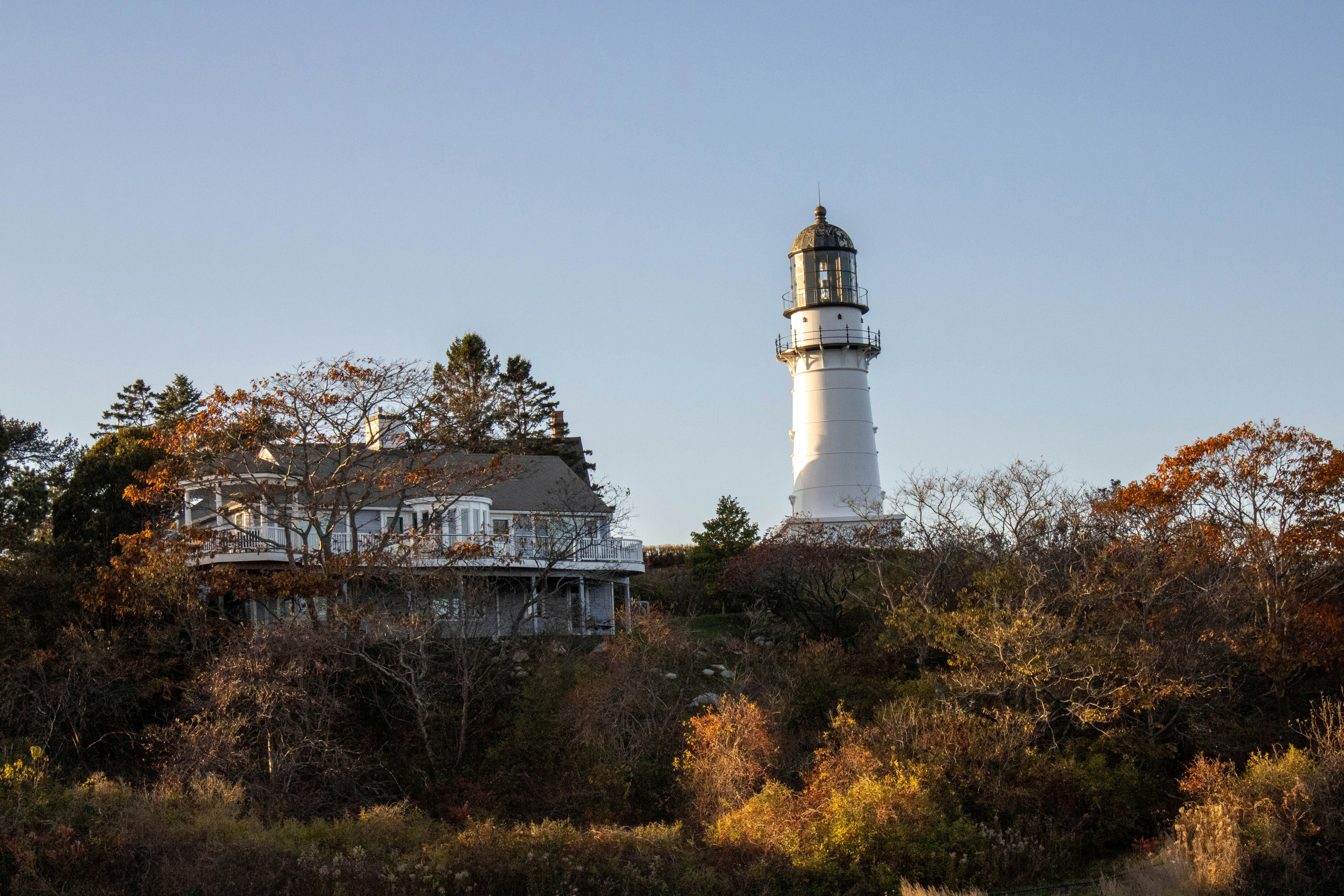 a light house sitting on top of a lush green hillside