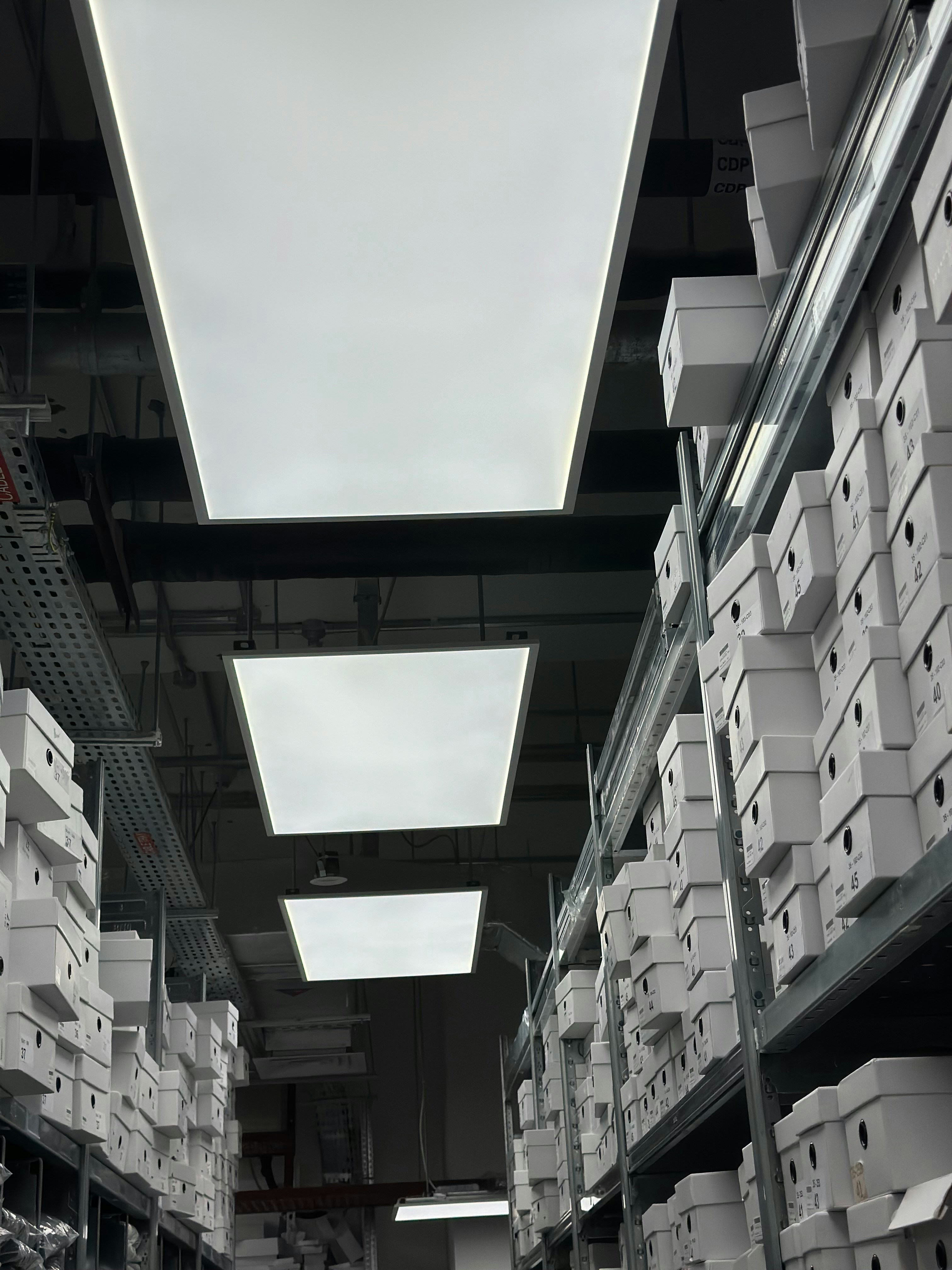 White industrial plastic sheets stacked in a clean warehouse, bright neutral lighting, high contrast