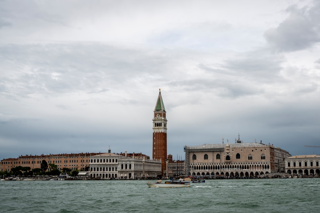 a large clock tower towering over a city next to a body of water, Venice city