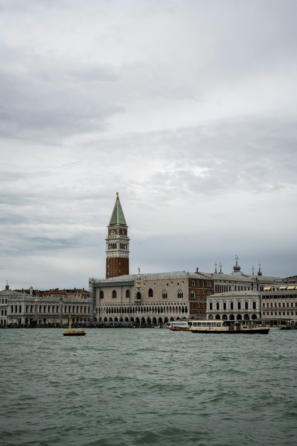 a large building with a clock tower next to a body of water