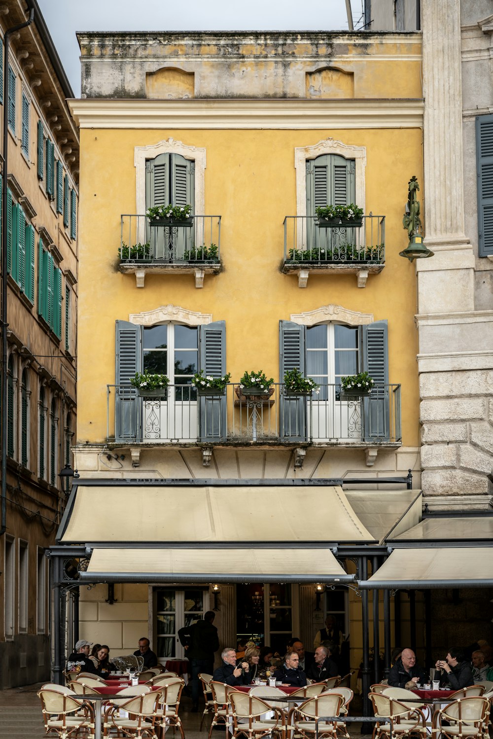 a group of people sitting at tables in front of a building