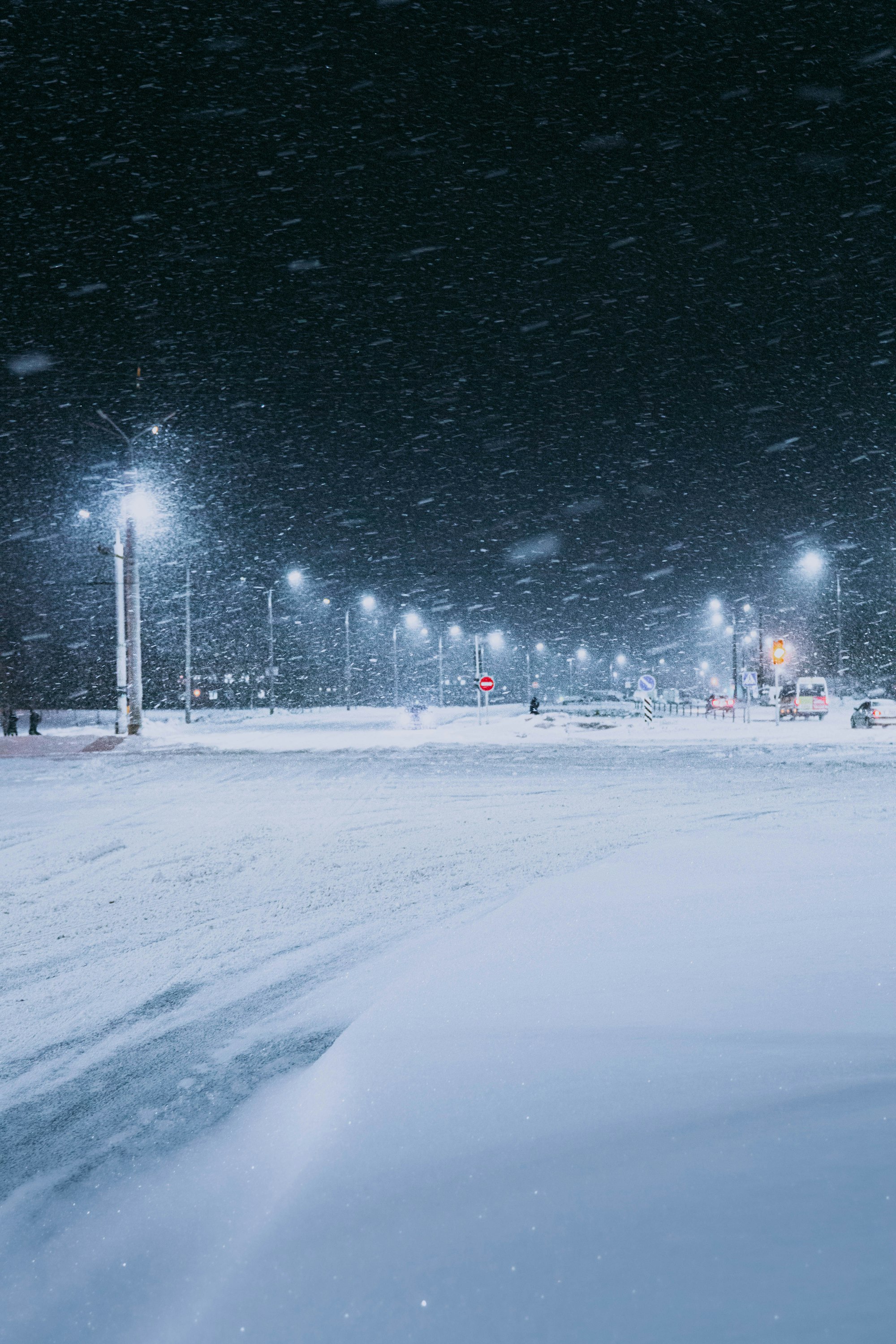 a snow covered parking lot at night with street lights