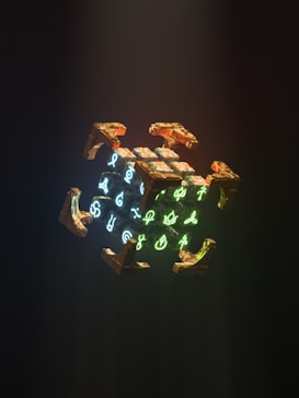 A glowing cube with mystical symbols is surrounded by metallic, angular appendages. The symbols on the cube are illuminated in bright neon colors, contrasting with the dark, shadowy background.