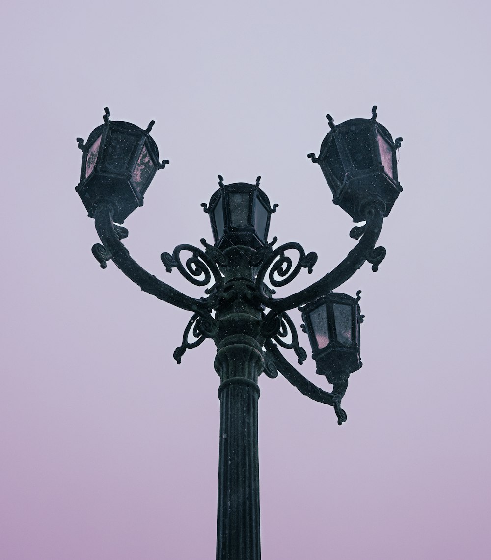 a street light with a pink sky in the background