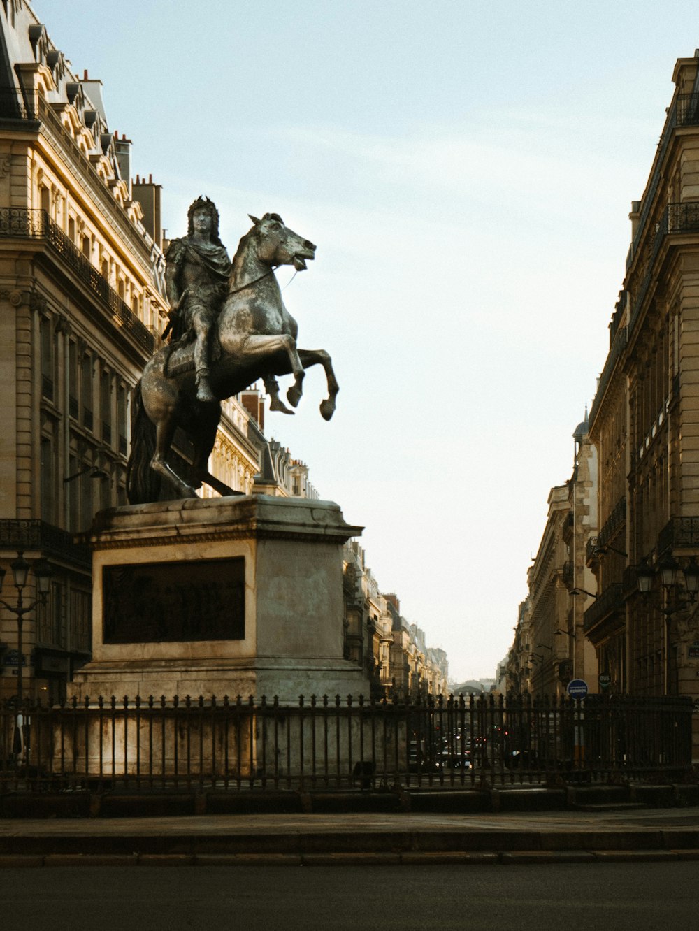 a statue of a man riding a horse in front of a building