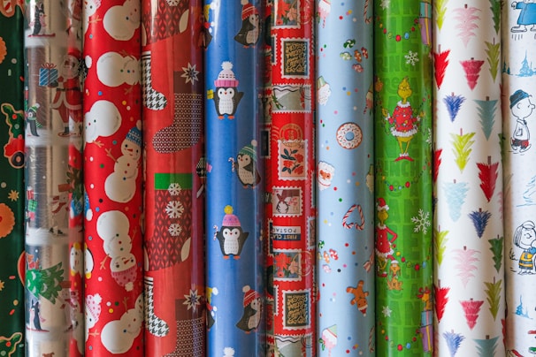 A stack of freshly printed gift wraps with bright, festive designs ready for packaging