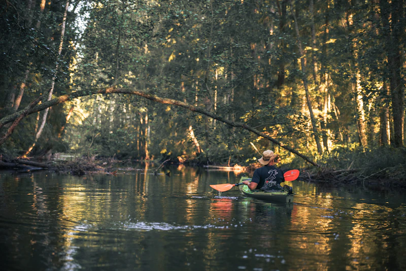 Young person paddling a canoe down a river
