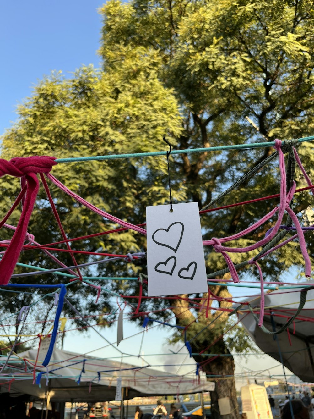 a sign with a heart on it hanging from a clothes line