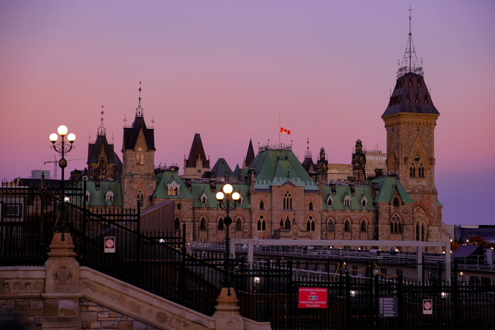 a large building with a clock tower next to a fence