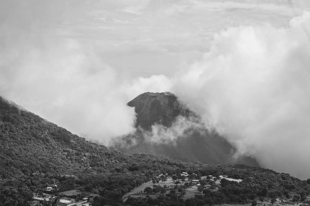 a black and white photo of a mountain with clouds