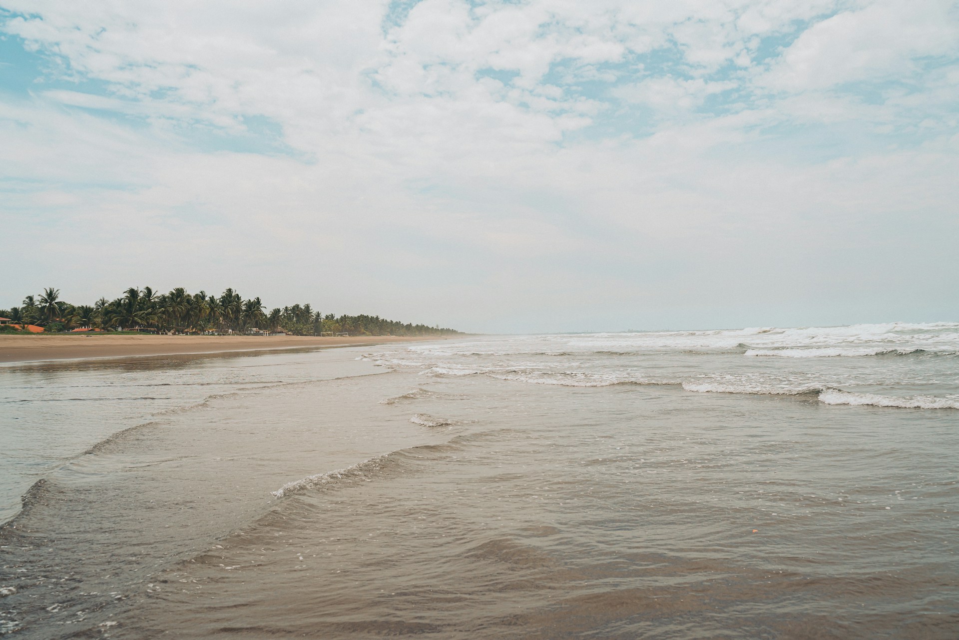 a sandy beach with waves coming in to shore