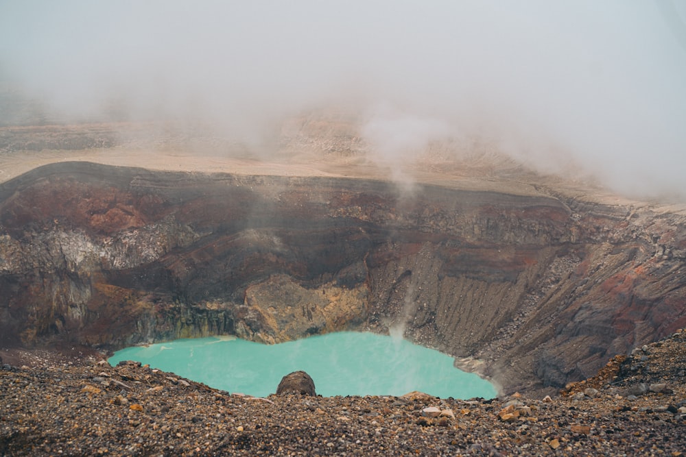 a large crater with a blue lake in the middle of it