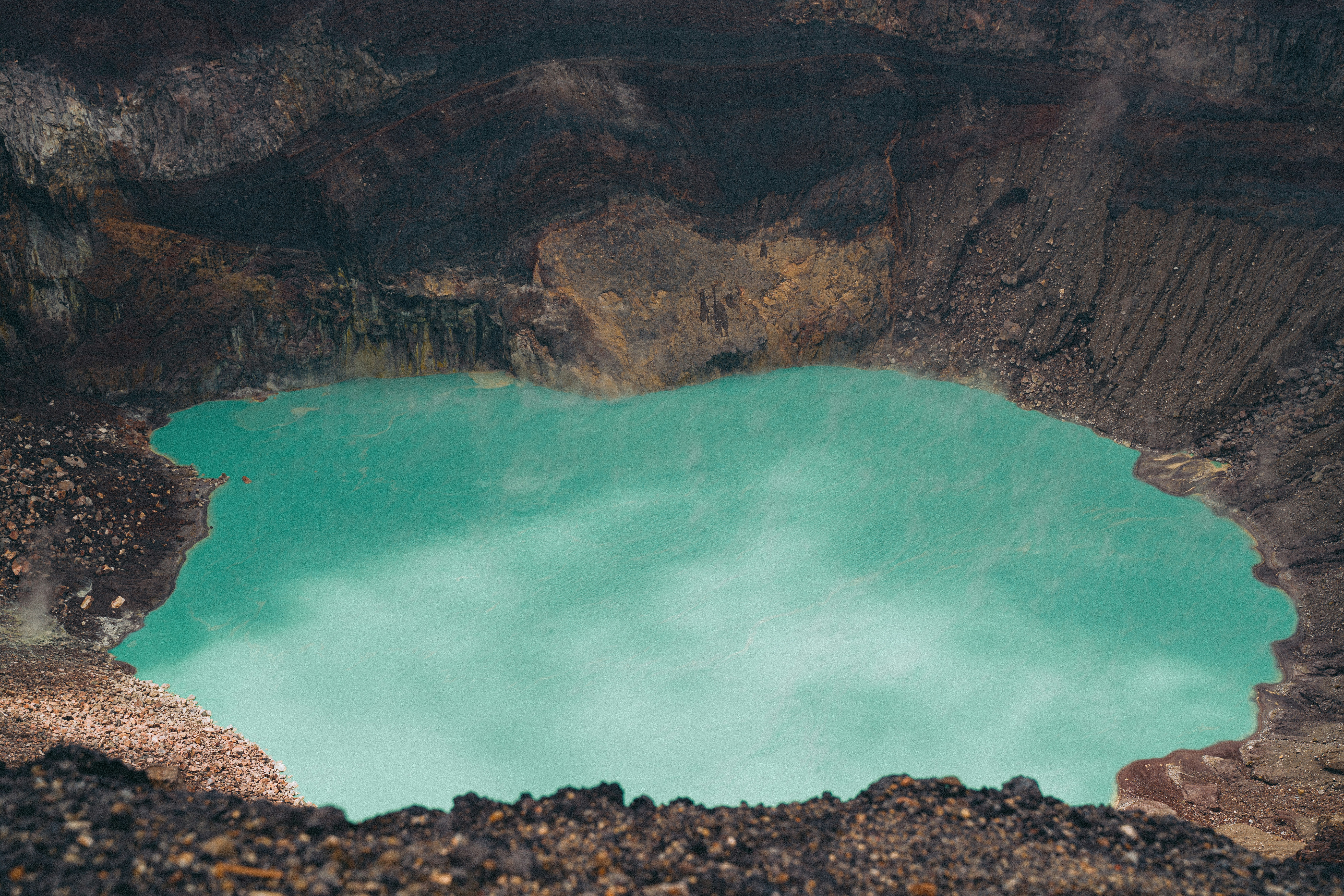 a large crater with a blue lake in the middle of it