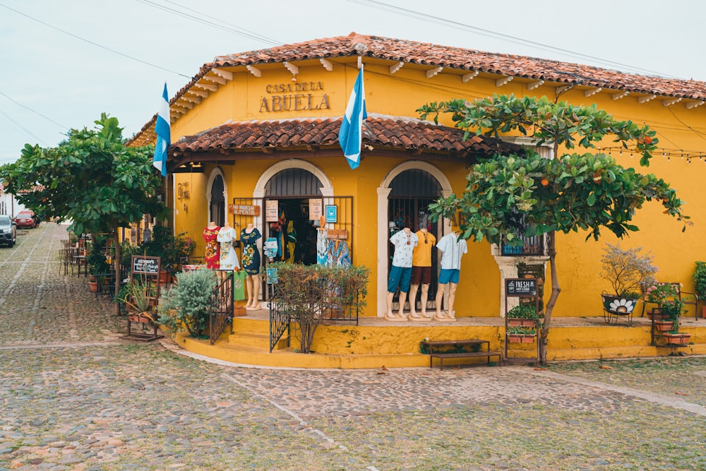 a group of people standing outside of a yellow building