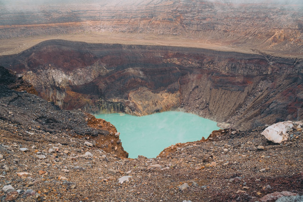 a large crater with a blue lake in the middle of it