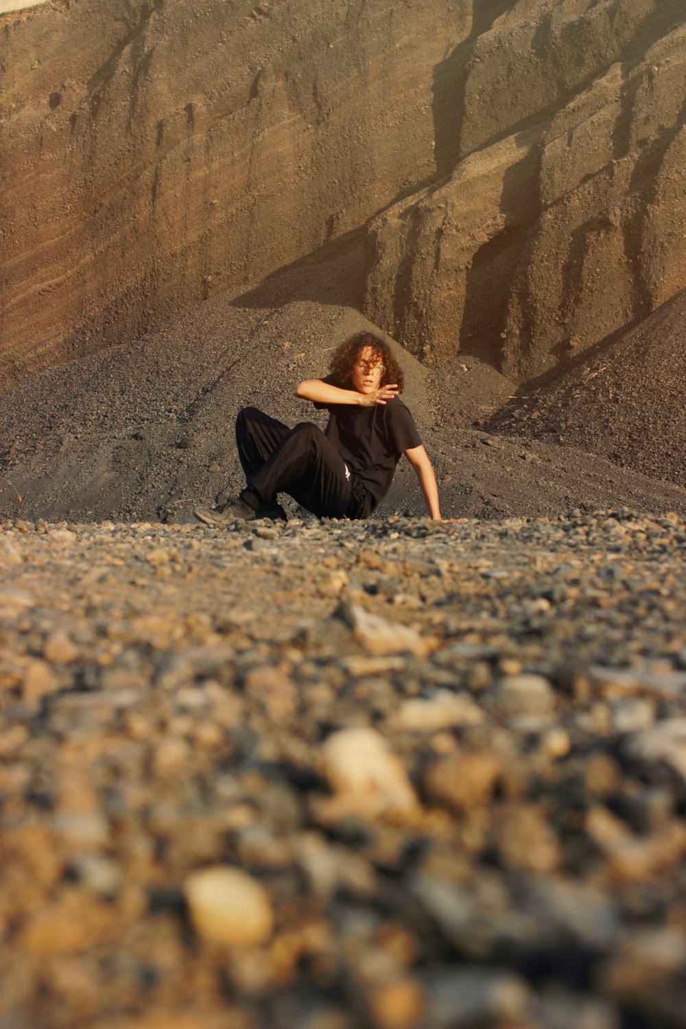 una donna seduta a terra di fronte a una montagna