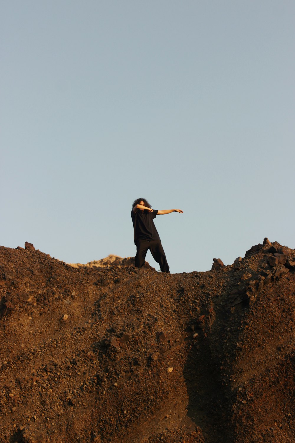 a man standing on top of a dirt hill