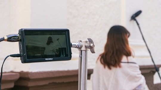 a woman standing next to a pole with a camera on it