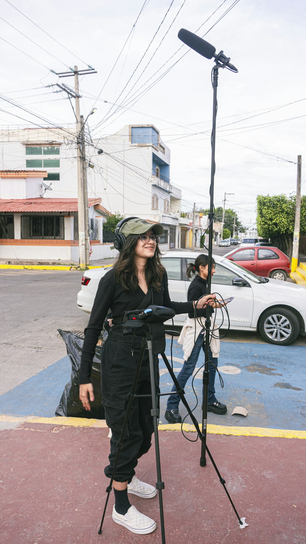 a woman standing in a parking lot holding a camera