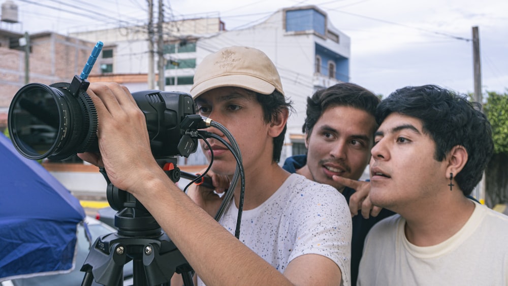 un groupe de jeunes hommes debout autour d’une caméra