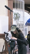 a woman with headphones and a camera on a tripod