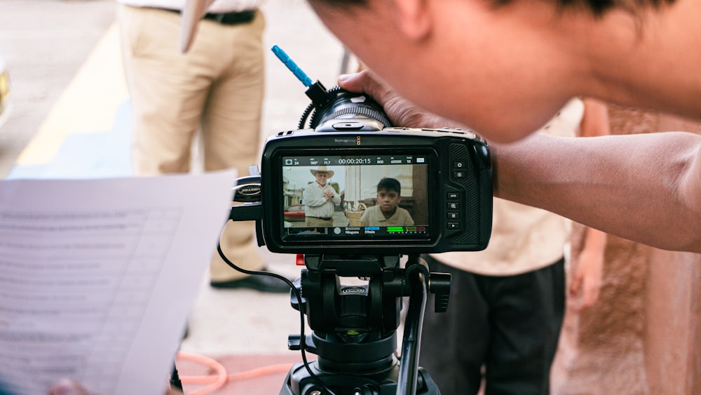 a person holding a camera with a video on it