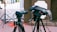 A professional videographer setting up equipment at an outdoor event.