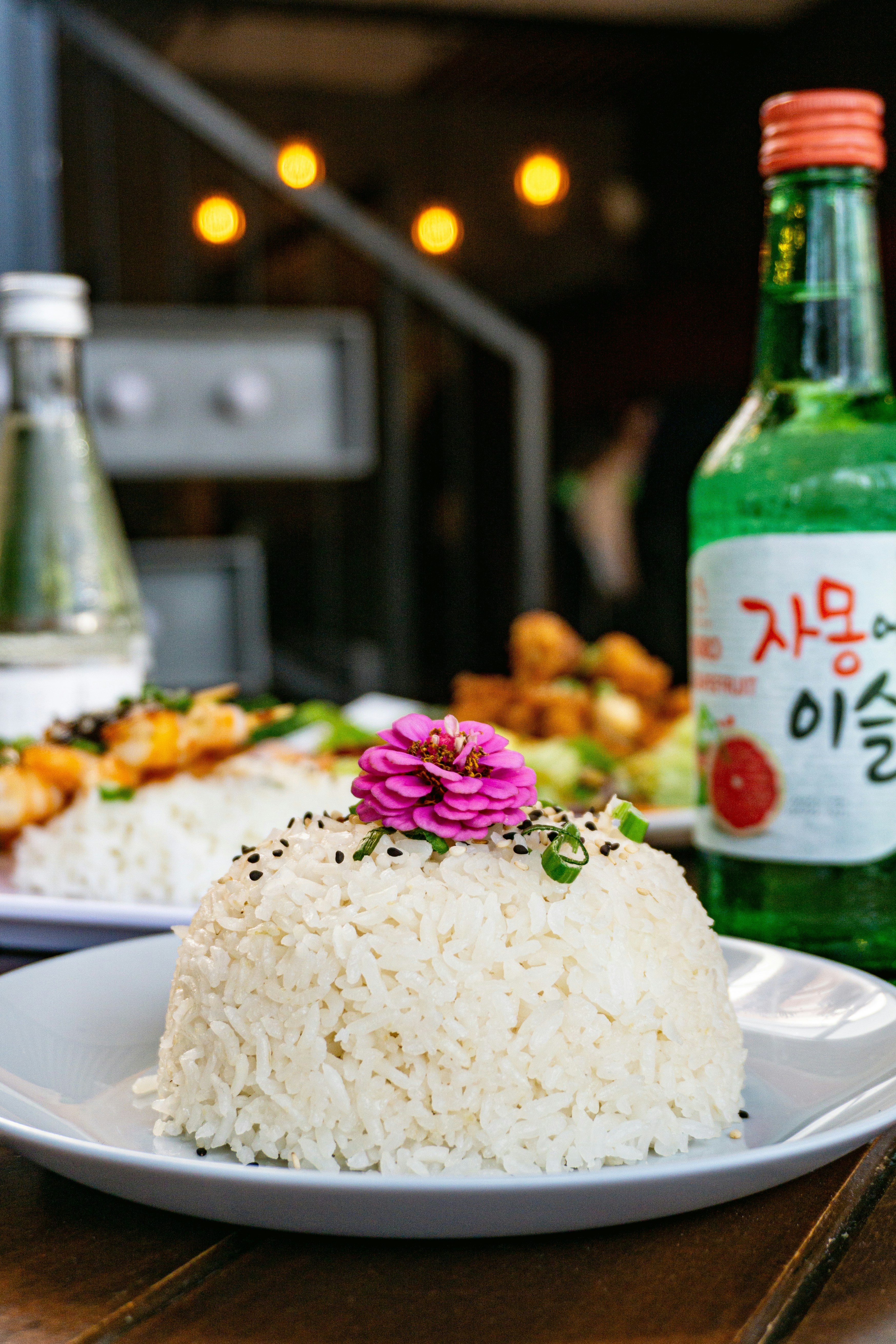 A white plate topped with rice next to a bottle of alcohol photo – Free ...