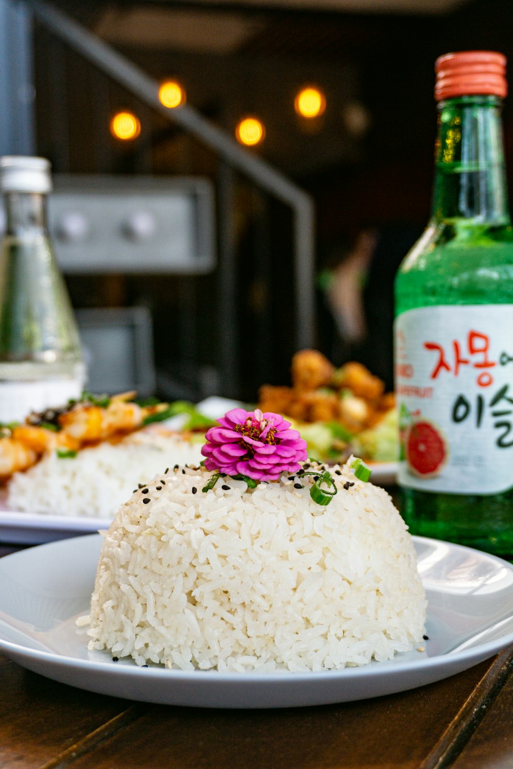 a white plate topped with rice next to a bottle of alcohol