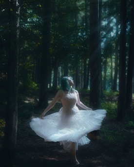A dancer gracefully moving through a forest clearing at golden hour, with soft light filtering through the trees.