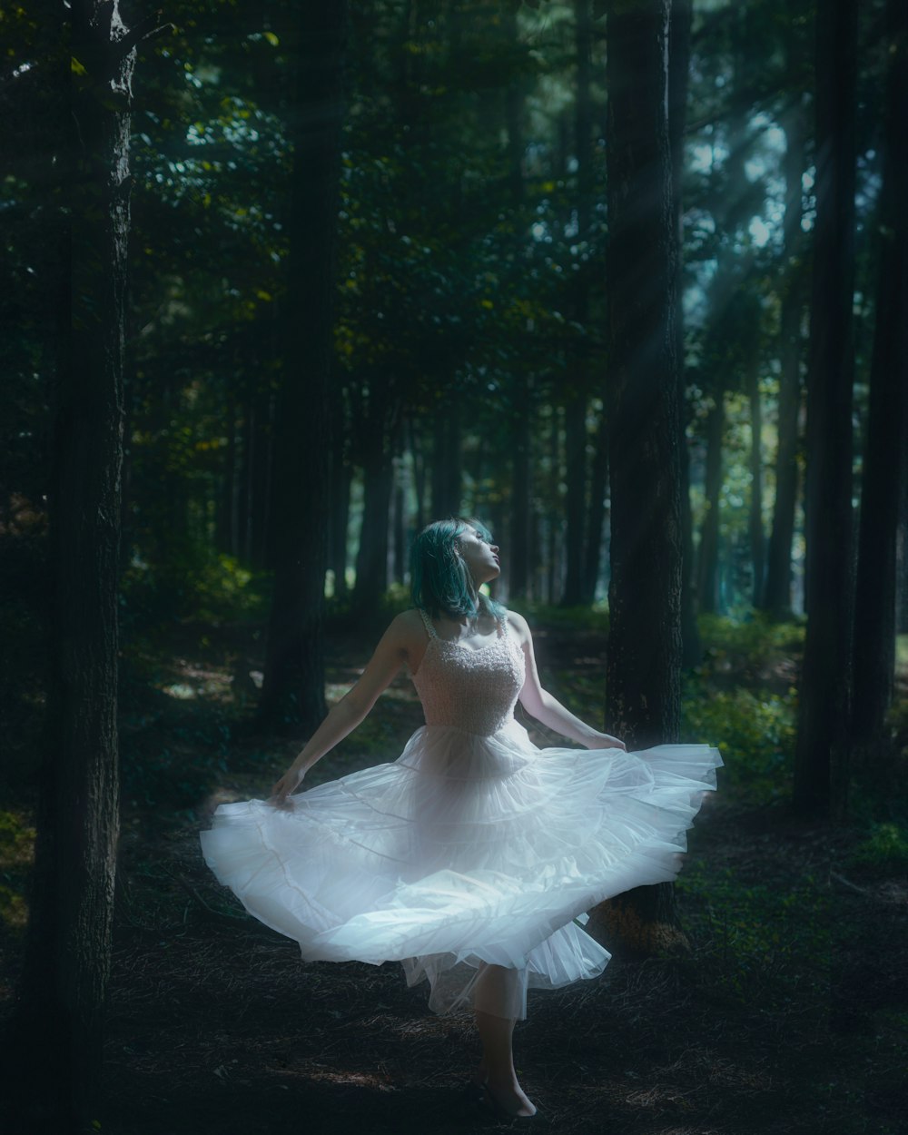 a woman in a white dress walking through a forest