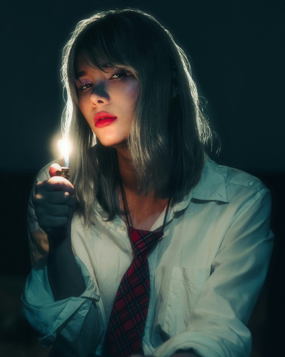 a woman holding a lighter in her hand