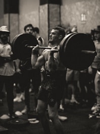 Close-up of a person lifting weights while being supported by a trainer in São José dos Campos.