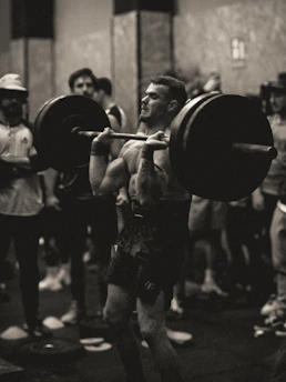 Trainer demonstrating proper lifting technique to a focused football player.