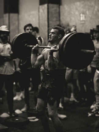 A close-up of a trainer guiding a student through weightlifting with focused encouragement.