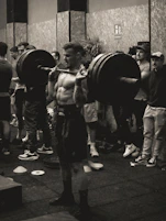Black and white photo of a personal trainer guiding a client through a workout session.
