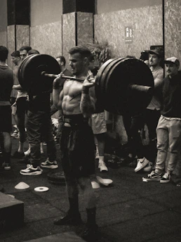 A sleek, dark-themed photo of a focused athlete lifting weights in a minimalist gym setting.